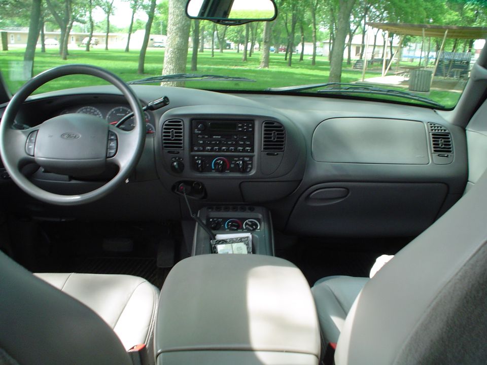 Interior dashboard of late-1990s Ford F-150 truck with gray cloth seats