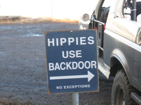 1991 Ford Bronco - A sign directs people to use the backdoor, with a vehicle parked nearby.