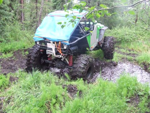 1990 Ford Bronco - Custom off-road buggy with large tires stuck in mud during an outdoor excursion.