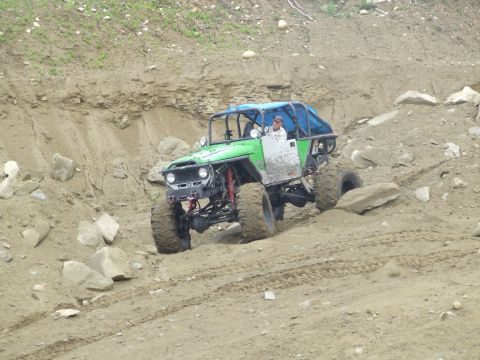 1990 Ford Bronco - Custom buggy navigates a challenging off-road terrain with steep inclines and loose dirt.