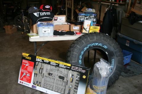 1990 Chevrolet Suburban - Various automotive parts and tools are displayed, including a large tire and a comprehensive tool kit.