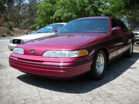 1992 Ford Crown Victoria - A maroon 1992 Ford Crown Victoria is parked in a lot, with another vehicle visible behind it.
