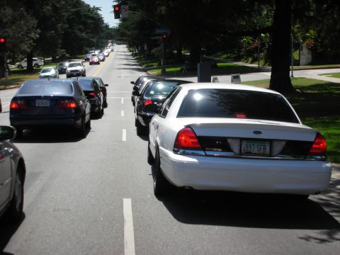1992 Ford Crown Victoria - A white 1992 Ford Crown Victoria is seen in traffic on a sunny day, with its license plate clearly visible.