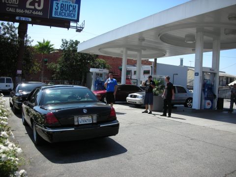 1992 Ford Crown Victoria - Several cars are parked at a gas station on a sunny day.