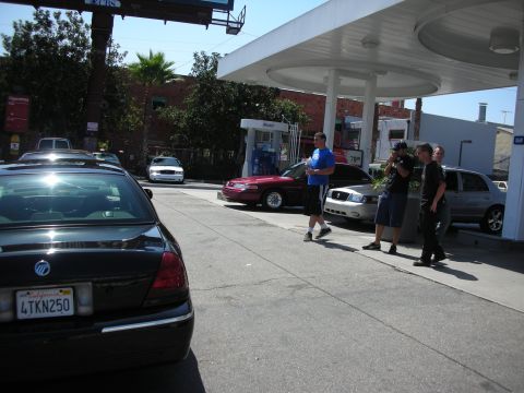 1992 Ford Crown Victoria - People stand near gas pumps as several cars are parked at the station.