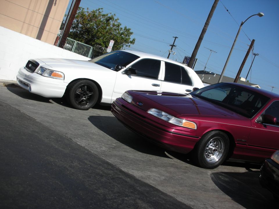 Maroon 1992 Ford Crown Victoria parked next to a white one