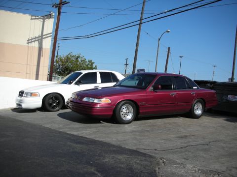 1992 Ford Crown Victoria - Two Ford Crown Victorias are parked side-by-side on a sunny day.
