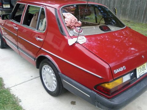 1987 Suzuki Samurai - This red sedan has "SAAB" badging on the rear, indicating it is not a 1987 Suzuki Samurai.