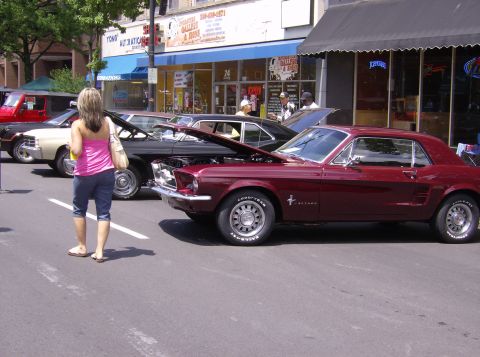 1970 Ford Ranchero - A maroon 1967 Ford Mustang coupe is displayed with its hood open at a car show.