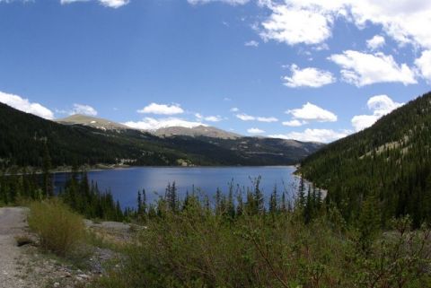 1993 Ford Bronco - A wide view of a mountain lake surrounded by dense pine forests and peaks.