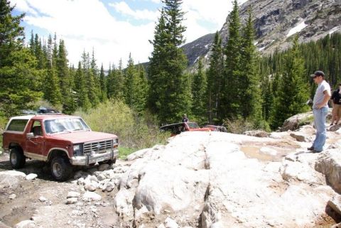 1993 Ford Bronco - Off-roading adventure in a mountainous, forested area with multiple vehicles.