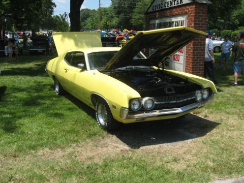 1972 Ford Ranchero - A yellow 1972 Ford Ranchero is displayed with its hood open at an outdoor event.