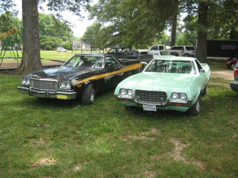 1972 Ford Ranchero - Two Ford Rancheros are parked on a grassy lawn under trees, with other vehicles in the background.