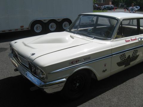1972 Ford Ranchero - A white 1962 Ford Fairlane with racing decals and a hood scoop is parked outdoors.