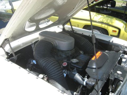 1972 Ford Ranchero - Close-up of a vehicle's engine bay, prominent air intake hoses and a glimpse of another car in the background.