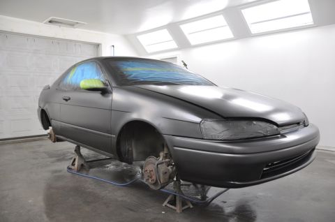 1996 Ford Bronco - Car body is prepped and masked for a new paint job in a spray booth.