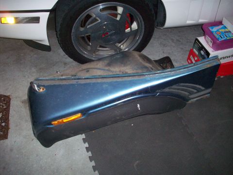 1978 Jeep CJ5 - A blue car fender with a black lower section and an orange reflector is shown.
