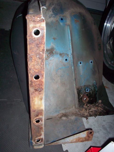 1978 Jeep CJ5 - A close-up view of a corroded blue metal automotive part with visible rust and mounting holes.