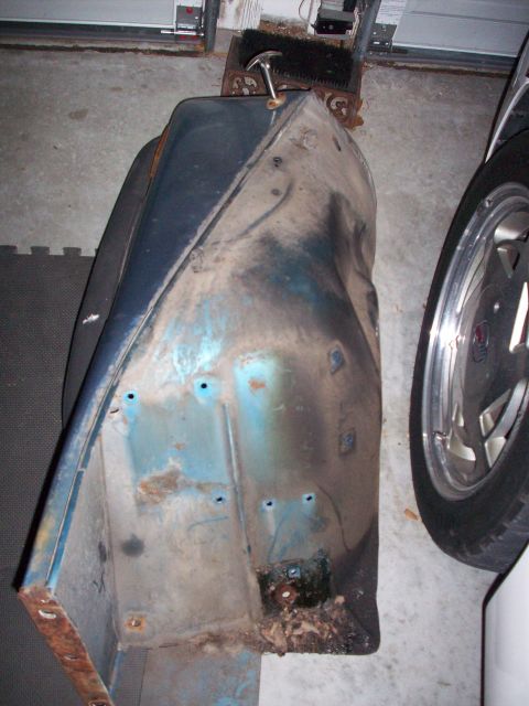 1978 Jeep CJ5 - A blue fender part, showing signs of rust and damage, is pictured indoors.
