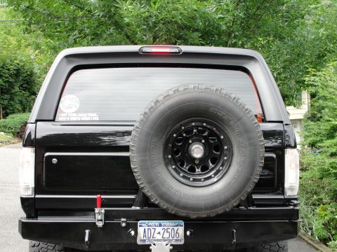 1995 Ford Bronco - Rear view of a black 1995 Ford Bronco, a spare tire on the tailgate and a New York license plate.