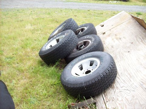 1995 Ford Bronco - A set of four tires are visible, some resting on a wooden surface.
