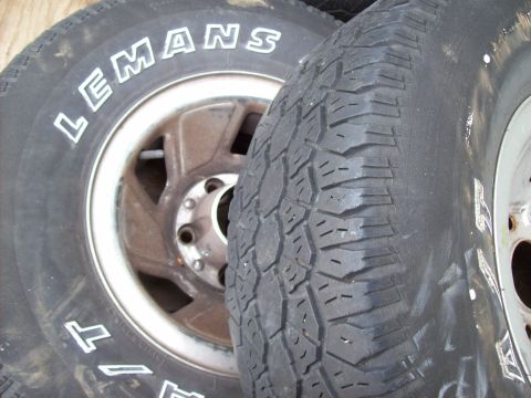 1995 Ford Bronco - Close-up view of two tires and rims, with white lettering visible on one tire.