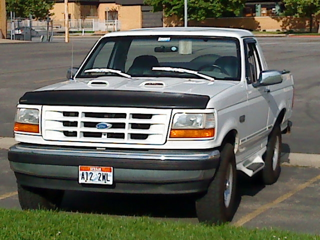 White Ford truck with a black bug deflector and a Utah license plate