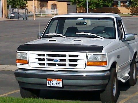 1995 Ford Bronco - This white 1995 Ford F-150 pickup truck is shown from the front, its distinctive grille and a Utah license plate.