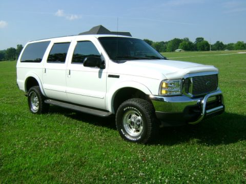2000 Ford Excursion - A white 2000 Ford Excursion is parked on a green lawn under a clear blue sky.