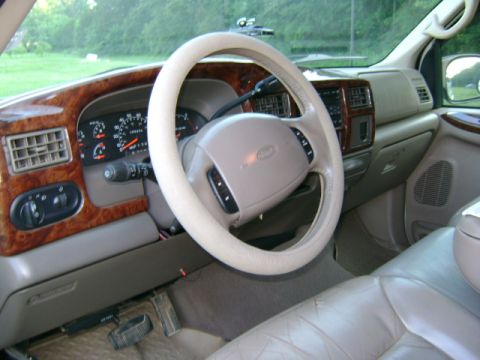 2000 Ford Excursion - The interior of a Ford Excursion features wood grain trim and a tan dashboard.