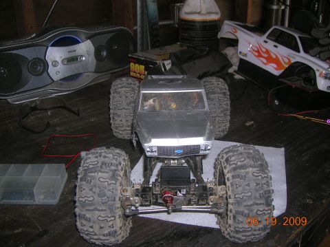 1985 Ford Bronco - A remote control monster truck sits on a workbench next to other hobby items, with a date stamp of 06.19.2009.