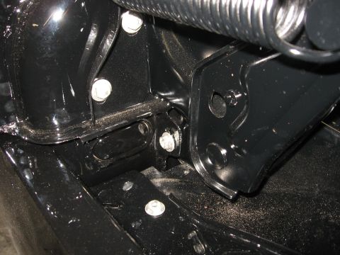 1966 Ford F-100 - Close-up view of black metal components and a spring, likely part of a vehicle's assembly or suspension system.
