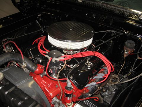 1966 Ford F-100 - Close-up of a vehicle's engine bay, a chrome air cleaner and bright red spark plug wires against a black background.