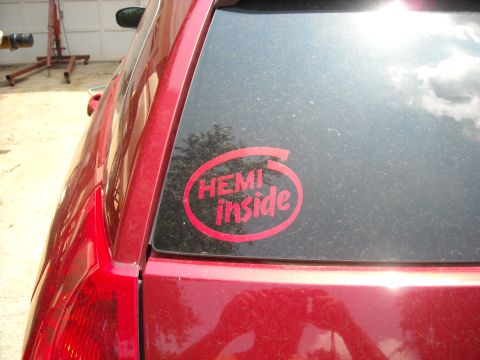 1979 Ford F-150 - A red vehicle's rear side is visible, showing a dusty window with a "HEMI inside" sticker.