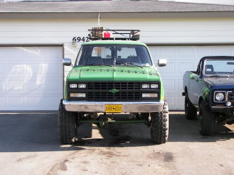 1990 Chevrolet Suburban - This 1990 Chevrolet Suburban is lifted and equipped with a roof rack, parked in front of a garage.