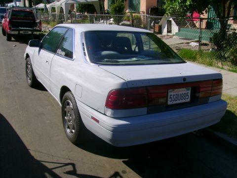 1989 Mazda MX-6 - This 1989 Mazda MX-6 coupe is seen from the rear, distinctive louvers on its back window.