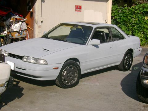 1989 Mazda MX-6 - Primer gray 1989 Mazda MX-6 coupe with a sunroof is parked outside.