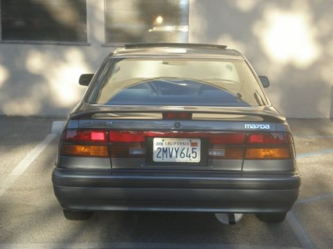 1989 Mazda MX-6 - The rear of a 1989 Mazda MX-6 shows its taillights and California license plate.