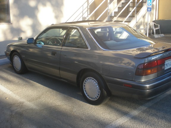 Gray Mazda MX-6 parked outside a building with stairs in the background