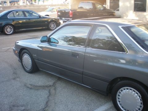 1989 Mazda MX-6 - This 1989 Mazda MX-6 coupe is seen from the side, with other vehicles in the background.