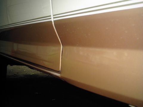 1995 Ford Bronco - Close-up of a vehicle's side panel showing a two-tone paint scheme and pinstripes.