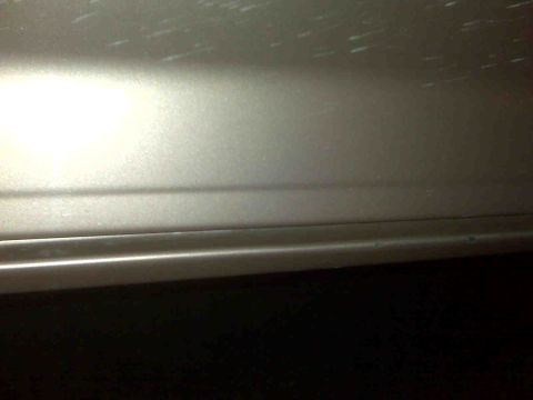 1995 Ford Bronco - Detail of a vehicle's door panel, showing a horizontal body line and some minor scuffs.