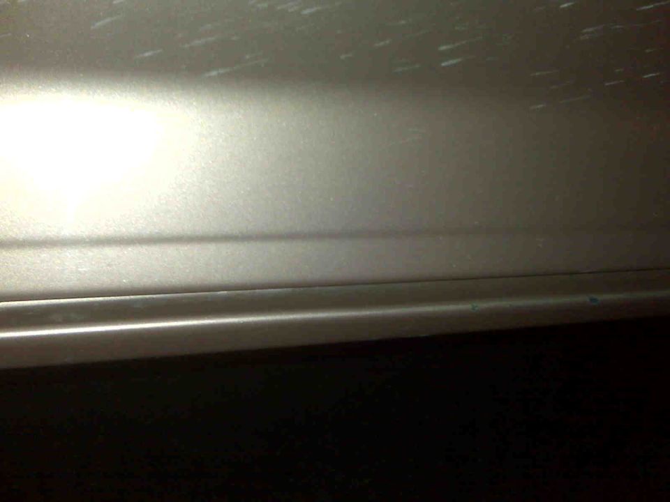 Close-up of a car's lower door panel with a horizontal body line