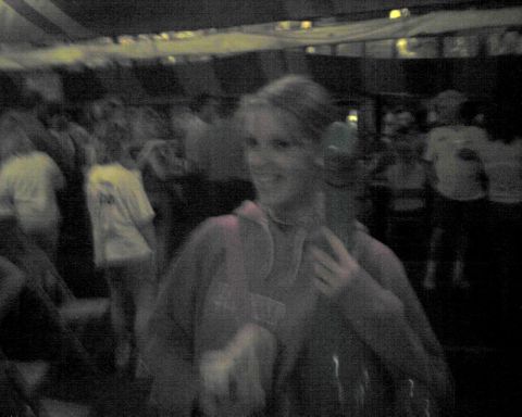 1990 Ford Taurus - A crowd of people gathered at an indoor event, with a woman smiling in the foreground.