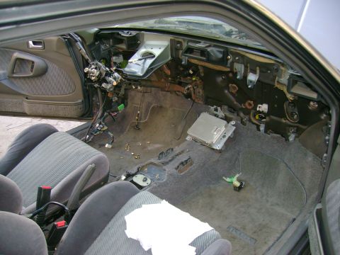 1989 Mazda MX-6 - The interior of a 1989 Mazda MX-6 shows a disassembled dashboard and exposed wiring.