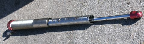 1984 Ford Bronco - This is a shock absorber, likely for an off-road vehicle, resting on a concrete surface.