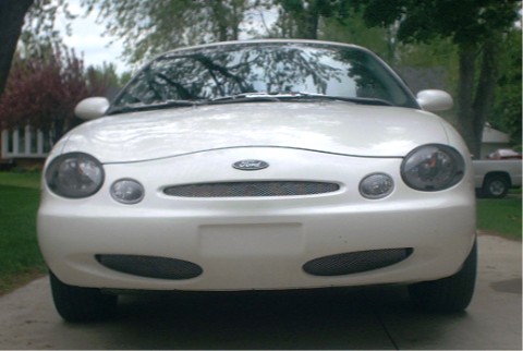 1997 Ford Taurus - Front view of a white 1997 Ford Taurus, showing its distinctive grille and headlights.