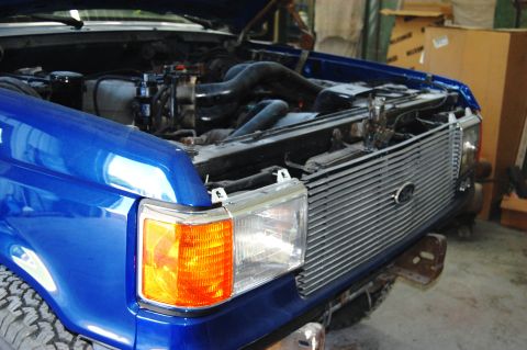 1989 Ford Bronco - Front view of a blue Ford truck's engine bay and grille, likely from the late 1980s.