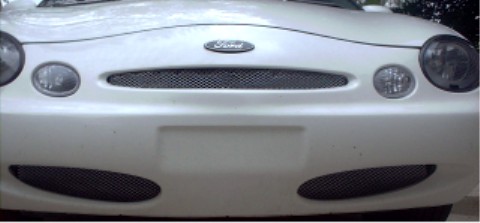 1997 Ford Taurus - Front view of a white 1997 Ford Taurus, its distinctive grille and oval headlights.