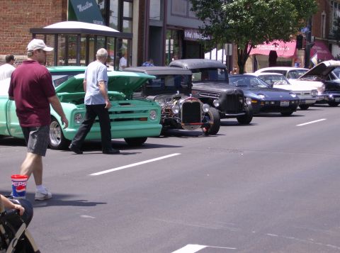 1970 Ford Ranchero - Cars are lined up on the street for a car show, with people walking around them.